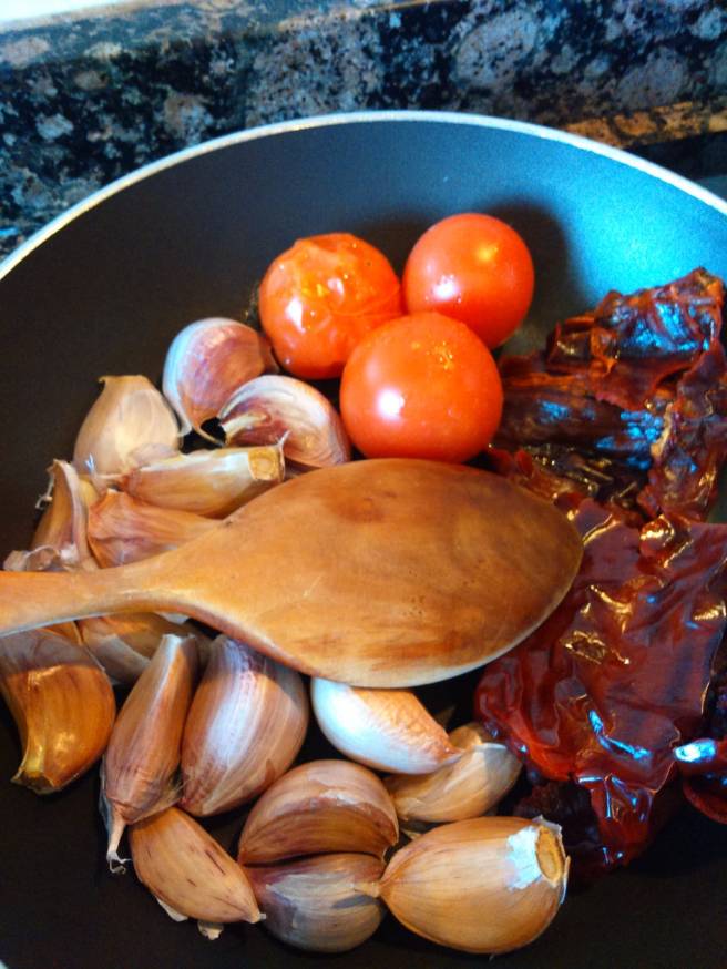 Els alls, les tomaquetes i el pebrot escalivant-se per al romesco