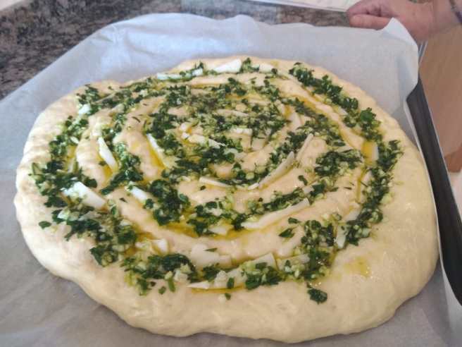 Coca amb mozarella, all i julivert, fermentada a punt d'enfornar